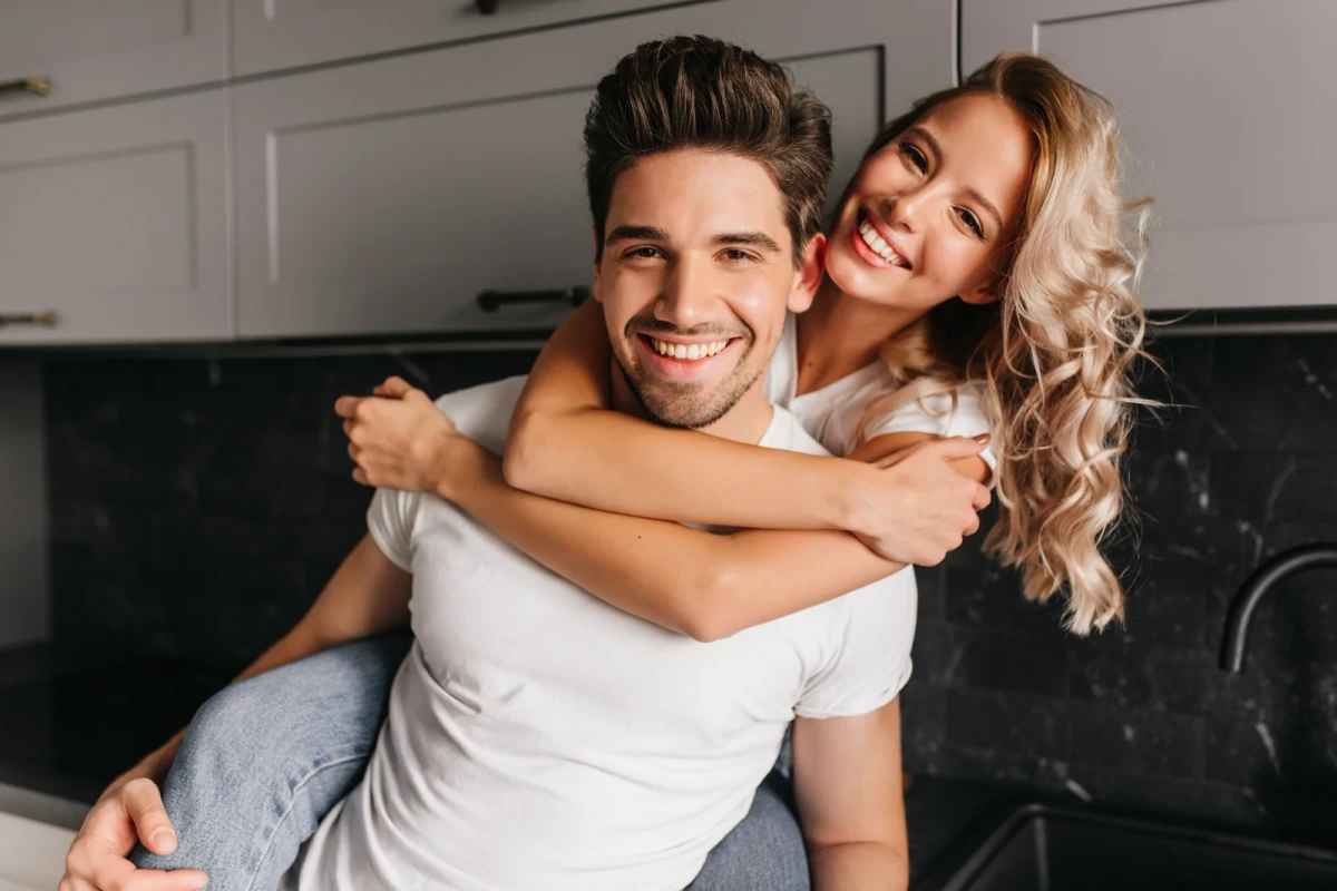 A smiling couple embracing in their kitchen